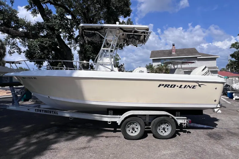 Slide: The Image of 2006 Pro-Line 23 Sport boat on trailer, parked outdoors under a clear blue sky. - 8