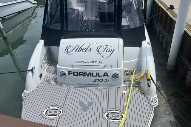 Slide: The Image of 2004 Formula 370 Super Sport boat docked, rear view with custom name "Abel's Toy." - 2