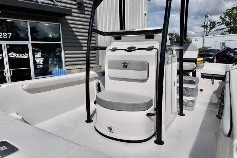 Slide: The Image of 2026 Carolina Skiff 21 LS boat interior with seating and console, parked outdoors. - 9