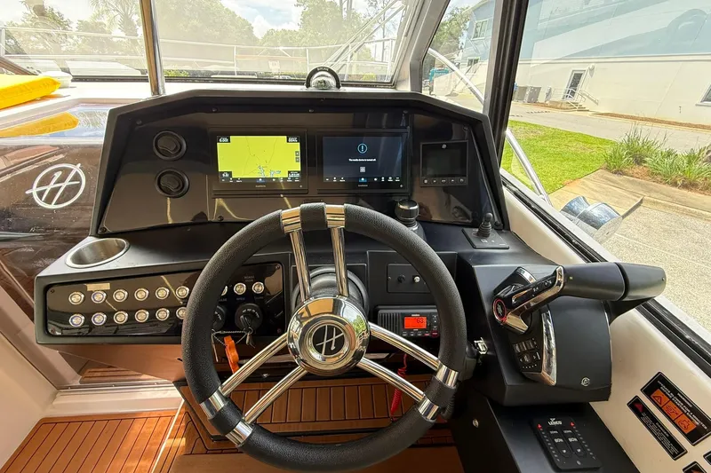Slide: The Image of 2024 Hanover 387 boat dashboard with steering wheel, navigation screens, and control panel. - 15
