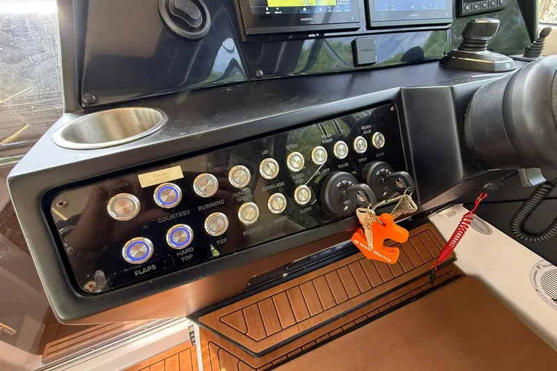 Slide: The Image of Control panel of a 2024 Hanover 387 boat with various switches and keys. - 17
