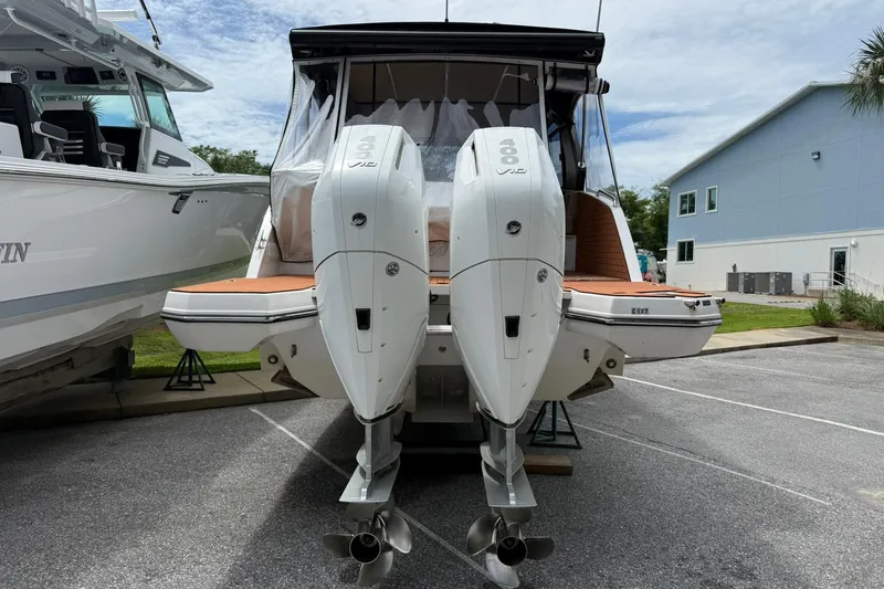Slide: The Image of 2024 Hanover 387 boat with dual outboard engines, docked in a marina. - 2