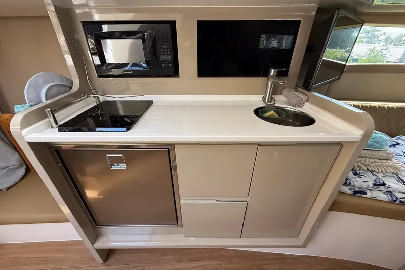 Slide: The Image of Compact kitchen area in a 2024 Hanover 387, featuring a sink, stove, and microwave. - 28