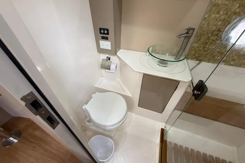Slide: The Image of Compact bathroom in 2024 Hanover 387 RV with modern fixtures and glass sink. - 32