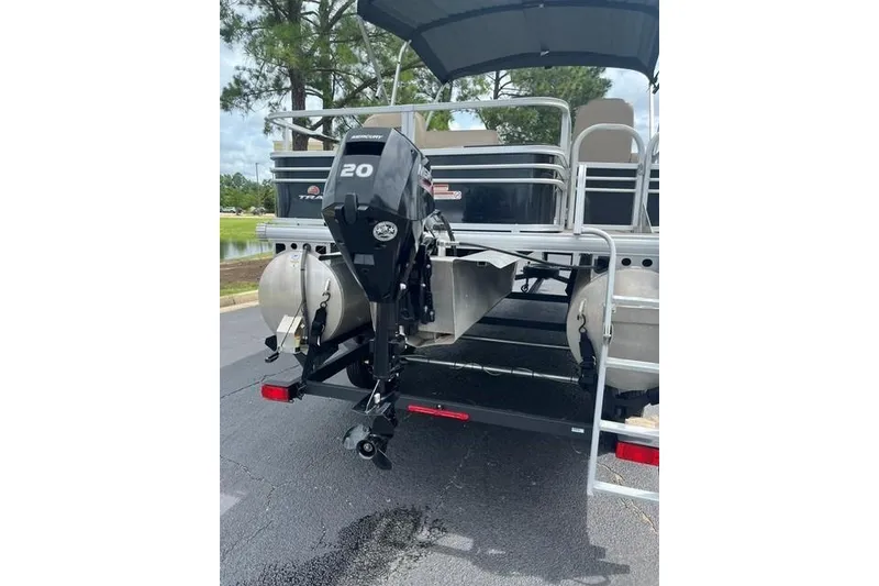 Slide: The Image of 2023 SUNTRACKER Fishing Barge 20 with Mercury outboard motor, parked on pavement. - 11