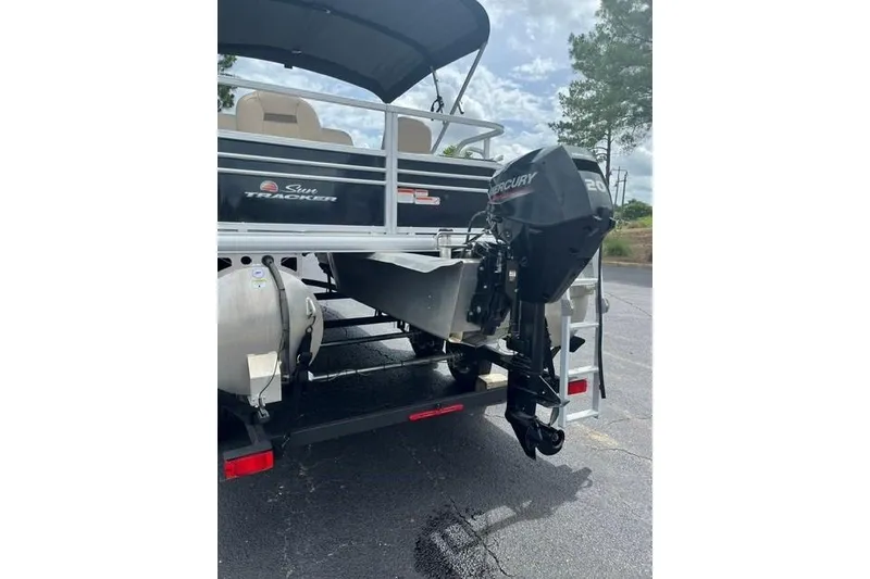 Slide: The Image of 2023 SUNTRACKER Fishing Barge 20 with Mercury outboard motor, parked on asphalt. - 12