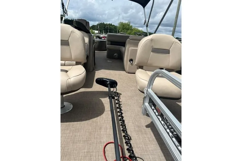 Slide: The Image of 2023 SUNTRACKER Fishing Barge 20 interior with beige seating and fishing equipment. - 3