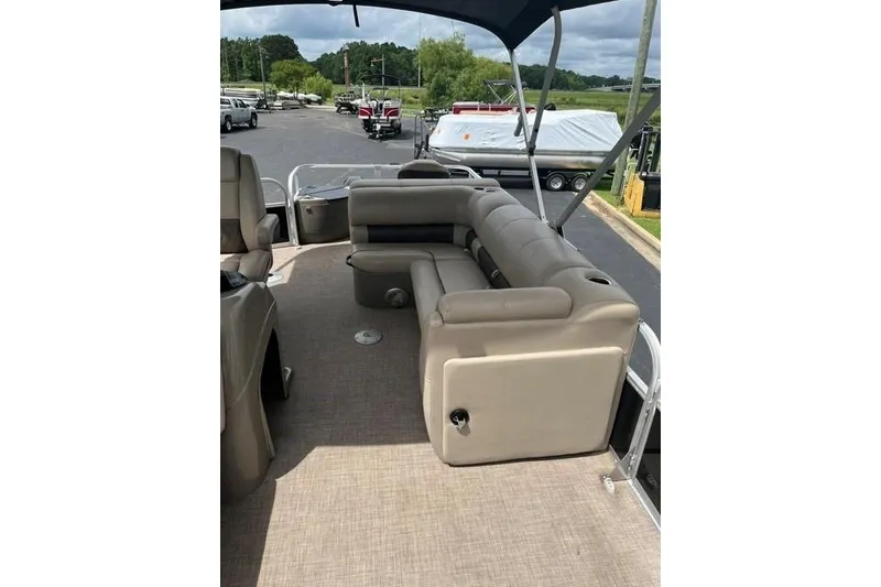 Slide: The Image of 2023 SUNTRACKER Fishing Barge 20 interior with beige seating and canopy. - 6
