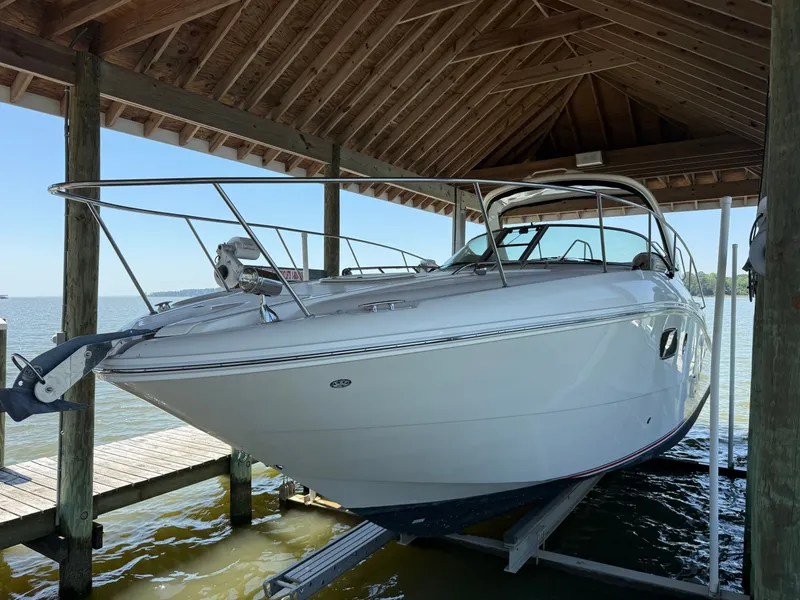 The Image of 2012 Sea Ray Sundancer 350 under a wooden shelter by the water. - 0