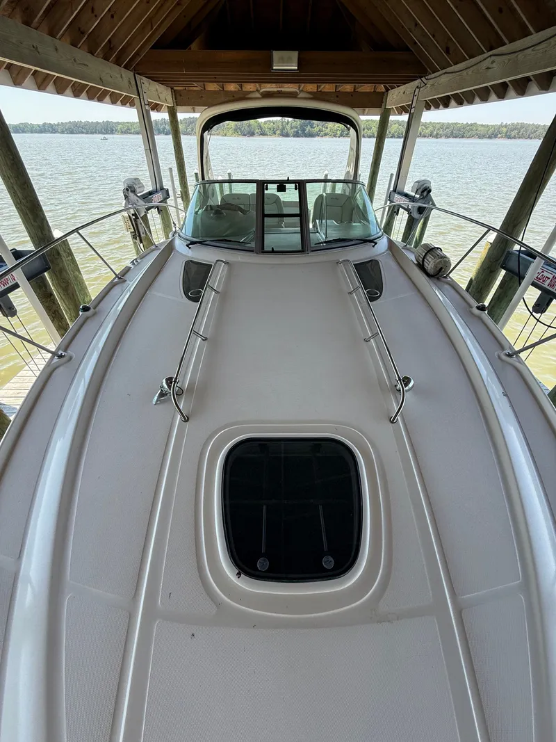Slide: The Image of 2012 Sea Ray Sundancer 350 on a lake under a wooden shelter. - 34