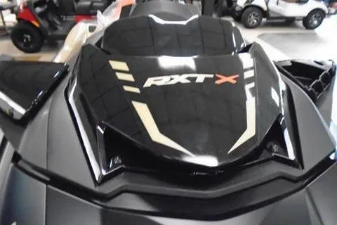 Slide: The Image of 2025 Sea-Doo RXT-X 325 jet ski, black with bold graphics, in showroom. - 3