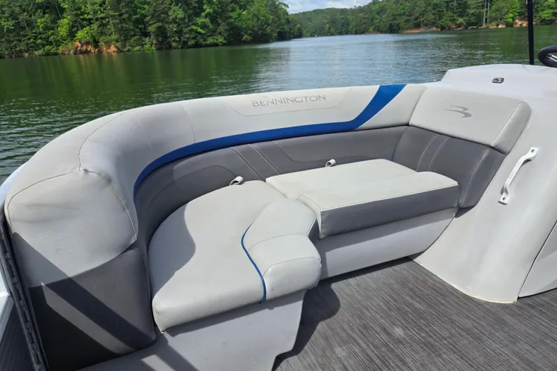 Slide: The Image of 2023 Bennington 22 SSR boat interior with plush seating on a serene lake. - 11