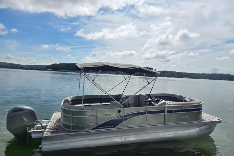 Slide: The Image of 2023 Bennington 22 SSR pontoon boat on a calm lake under a cloudy sky. - 4