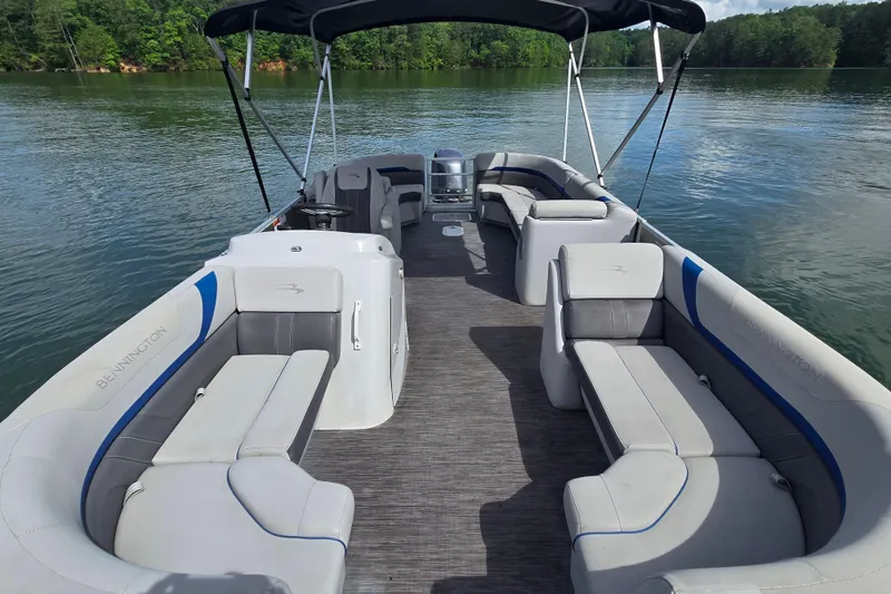 Slide: The Image of 2023 Bennington 22 SSR pontoon boat with spacious seating on a serene lake. - 9