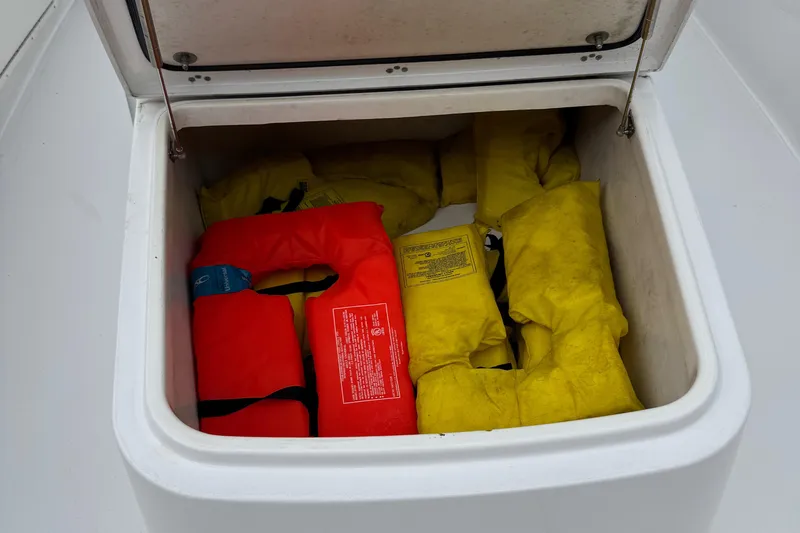 Slide: The Image of Storage compartment with life jackets on a 2020 Sportsman Open 282TE Center Console boat. - 16