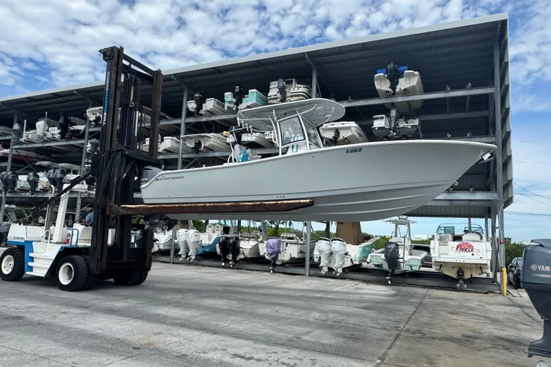 Slide: The Image of 2020 Sportsman Open 282TE Center Console boat lifted by forklift in marina storage. - 2