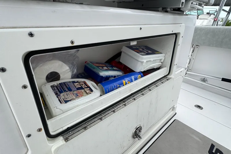 Slide: The Image of Storage compartment on a 2020 Sportsman Open 282TE Center Console boat with supplies. - 26