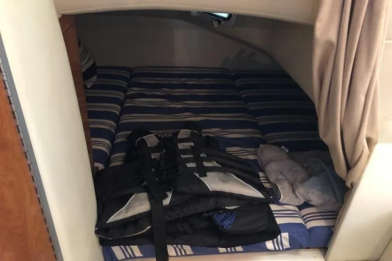 Slide: The Image of Interior cabin of 2006 Four Winns 258 Vista boat with striped bedding and life jackets. - 11