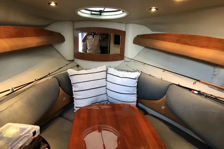 Slide: The Image of Interior of 2006 Four Winns 258 Vista boat with cozy seating and wooden table. - 8