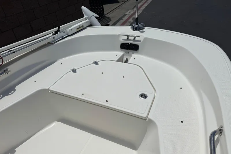 Slide: The Image of 2019 Boston Whaler 150 Montauk boat interior, featuring a clean, white deck and storage compartment. - 11