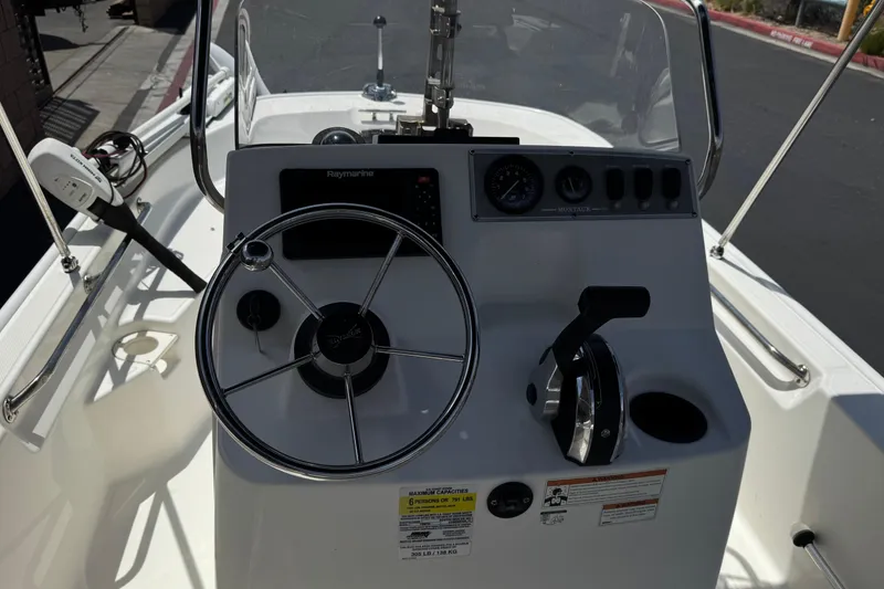 Slide: The Image of 2019 Boston Whaler 150 Montauk boat console with steering wheel and controls. - 19