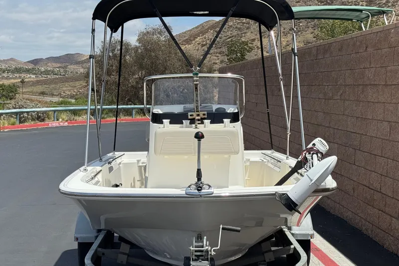 Slide: The Image of 2019 Boston Whaler 150 Montauk boat on trailer, parked outdoors. - 2
