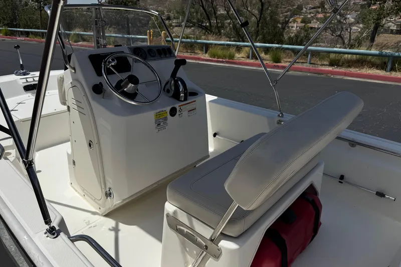 Slide: The Image of 2019 Boston Whaler 150 Montauk boat interior with steering console and seating. - 21
