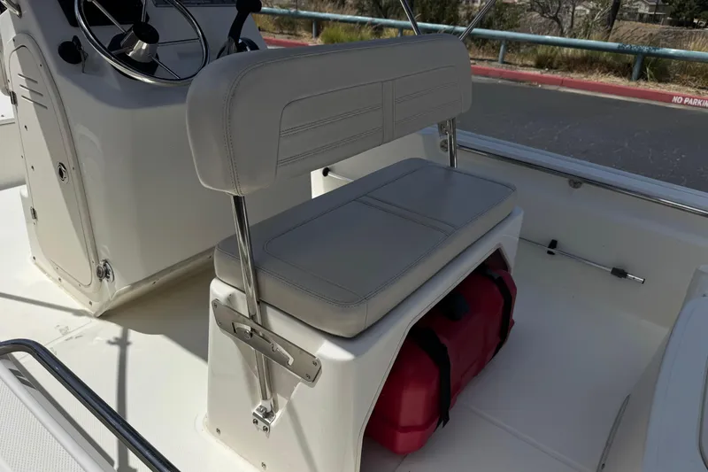 Slide: The Image of 2019 Boston Whaler 150 Montauk interior with seating and storage area. - 22