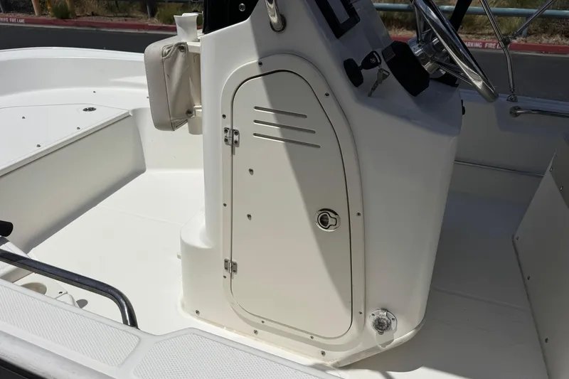Slide: The Image of 2019 Boston Whaler 150 Montauk boat console with steering wheel and storage compartment. - 24