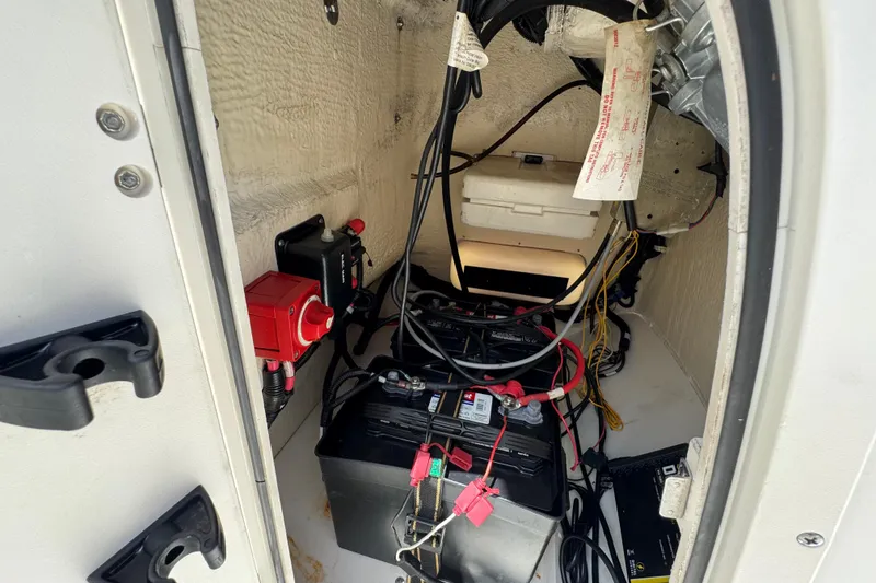 Slide: The Image of 2019 Boston Whaler 150 Montauk battery compartment with wiring and electrical components. - 25