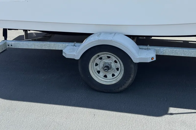 Slide: The Image of Trailer wheel of a 2019 Boston Whaler 150 Montauk boat on pavement. - 26
