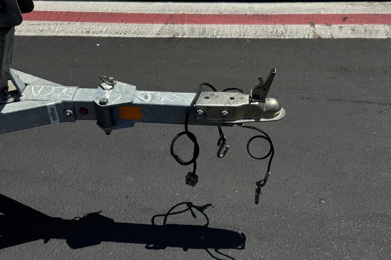 Slide: The Image of Trailer hitch of a 2019 Boston Whaler 150 Montauk on asphalt road. - 27