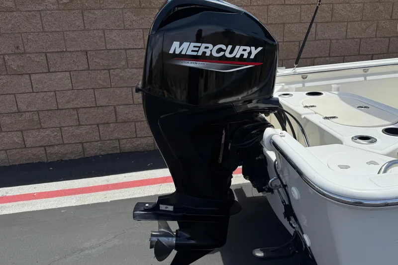 Slide: The Image of 2019 Boston Whaler 150 Montauk with Mercury outboard motor, parked near a brick wall. - 6