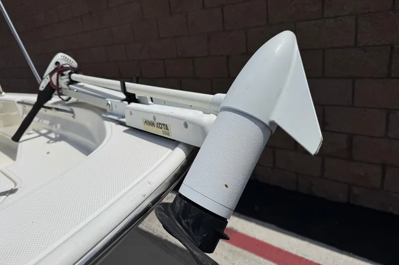 Slide: The Image of 2019 Boston Whaler 150 Montauk with Minn Kota Edge trolling motor, docked near a brick wall. - 8