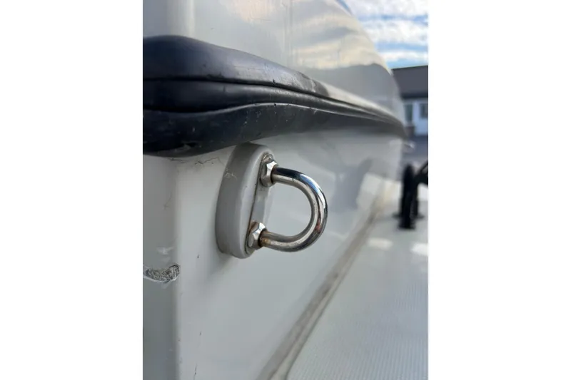 Slide: The Image of Close-up of a 2010 Dusky 256 Center Console boat's metal cleat on the side. - 13