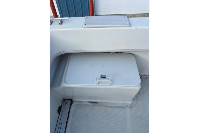 Slide: The Image of 2010 Dusky 256 Center Console boat storage compartment with latch, clean and spacious design. - 17