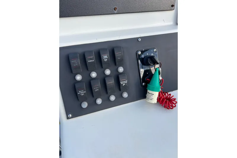 Slide: The Image of Control panel of a 2010 Dusky 256 Center Console boat with switches and ignition key. - 22