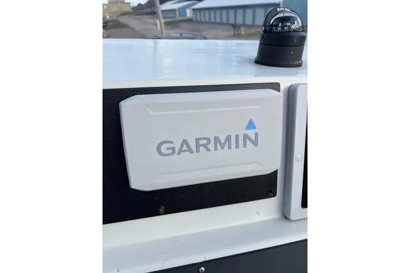 Slide: The Image of Garmin device on 2010 Dusky 256 Center Console boat dashboard with compass. - 23