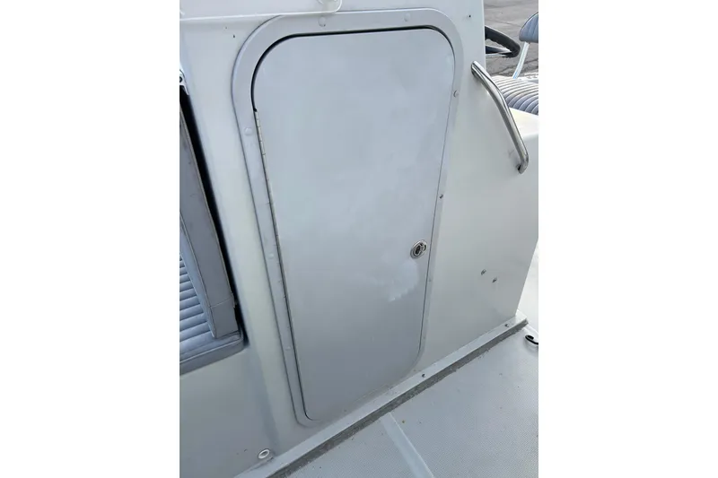 Slide: The Image of Dusky 256 Center Console 2010 boat compartment door with handle and lock. - 30