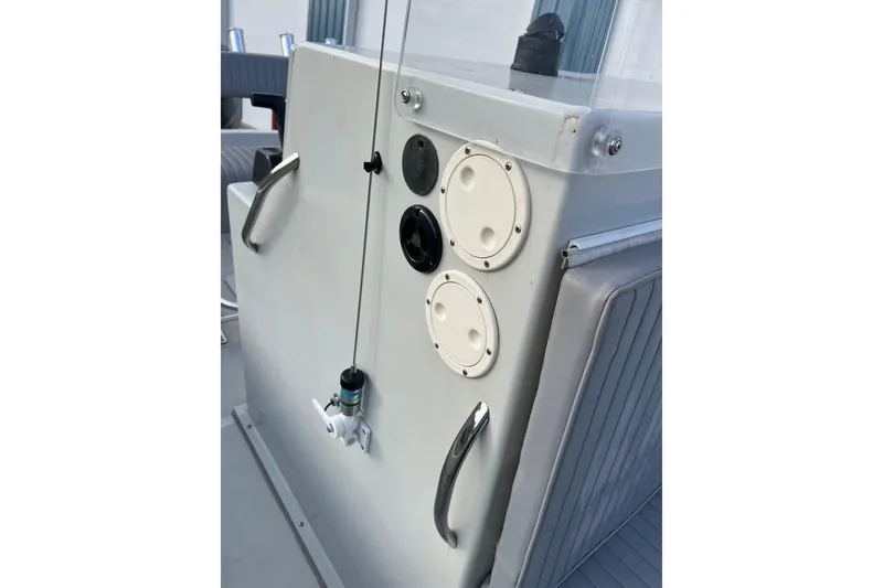 Slide: The Image of Dusky 256 Center Console 2010 boat dashboard with controls and rod holder. - 33