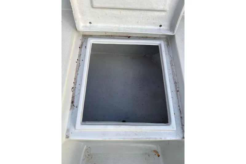Slide: The Image of Open storage compartment on a 2010 Dusky 256 Center Console boat. - 39