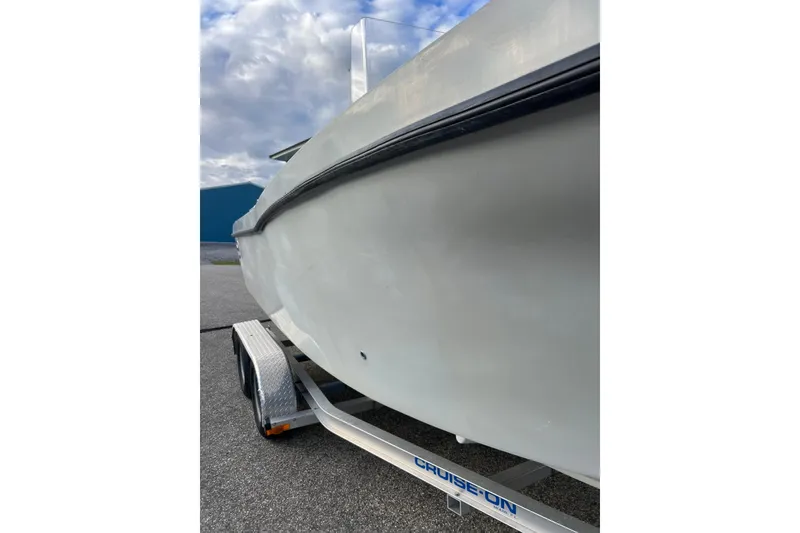 Slide: The Image of 2010 Dusky 256 Center Console boat on trailer under cloudy sky. - 4