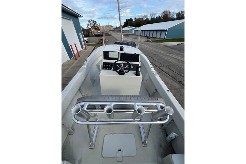 Slide: The Image of 2010 Dusky 256 Center Console boat with Garmin navigation, docked near industrial buildings. - 46