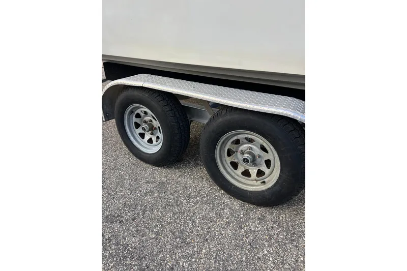 Slide: The Image of Trailer wheels of a 2010 Dusky 256 Center Console boat on asphalt. - 6