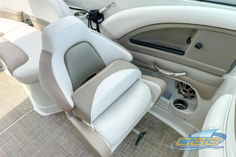 Slide: The Image of 2015 Crownline Eclipse E6 boat interior with beige and white seating, cup holders, and speaker. - 15