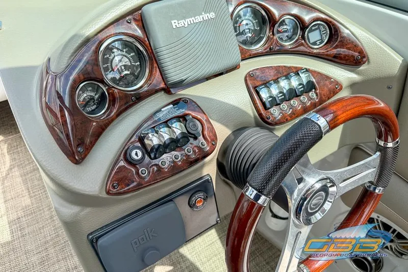Slide: The Image of Dashboard of a 2015 Crownline Eclipse E6 boat with wood accents and steering wheel. - 17