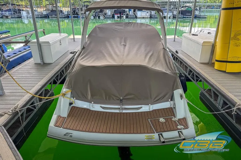 Slide: The Image of 2015 Crownline Eclipse E6 boat docked, covered, with wooden deck and marina backdrop. - 43