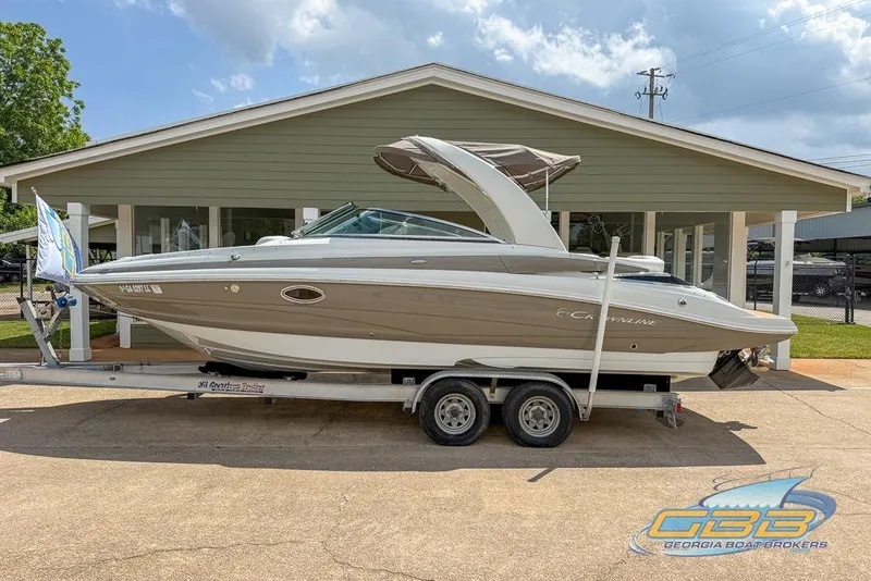 Slide: The Image of 2015 Crownline Eclipse E6 boat on trailer, parked outside a building. - 8