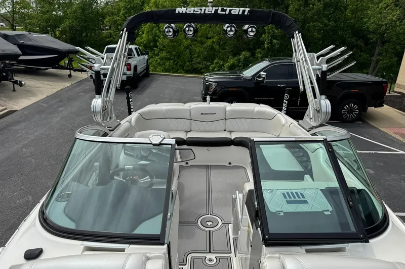 Slide: The Image of 2014 MasterCraft X-35 boat interior with seating and wakeboard tower in parking lot. - 20