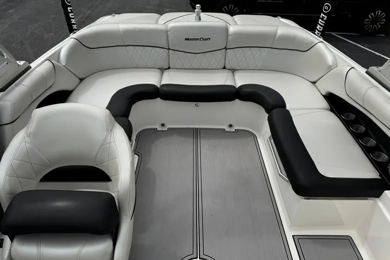 Slide: The Image of 2014 MasterCraft X-35 boat interior with white and black seating, cup holders, and sleek design. - 21